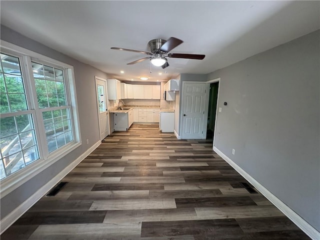 710 N Willis Ave, Independence, MO 64050 - kitchen with a sink, white cabinetry, baseboards, a ceiling fan, and dark wood-type flooring