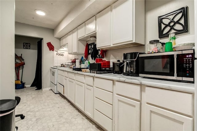 2713-2715 Benton Blvd, Kansas City, MO 64128 - kitchen featuring stainless steel microwave, white electric range, light countertops, white cabinetry, and recessed lighting