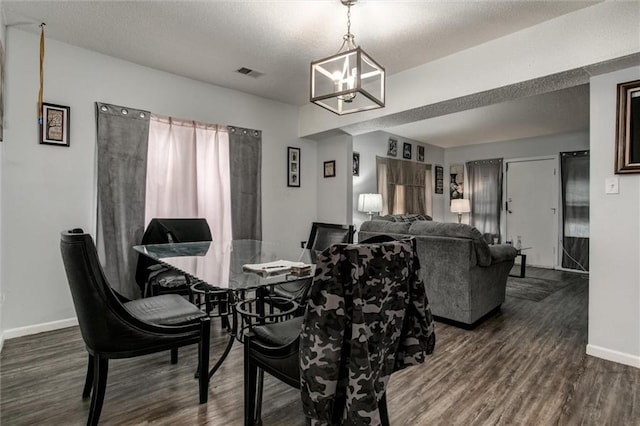 2713-2715 Benton Blvd, Kansas City, MO 64128 - dining area featuring wood finished floors, baseboards, a chandelier, and a textured ceiling