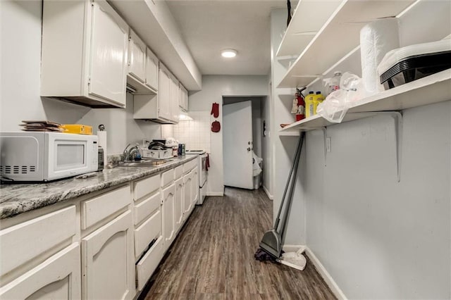 2713-2715 Benton Blvd, Kansas City, MO 64128 - kitchen featuring white appliances, open shelves, dark wood-type flooring, and white cabinetry