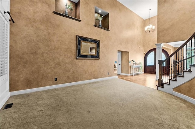 16249 Stearns St, Overland Park, KS 66221 - carpeted entrance foyer with baseboards, ornate columns, stairs, a chandelier, and a towering ceiling