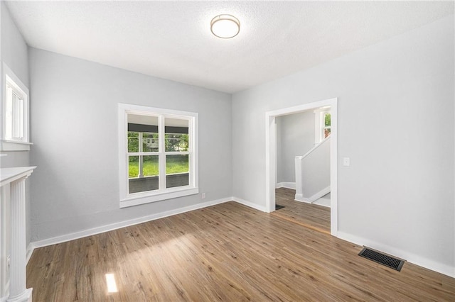 2206 E 30th St, Kansas City, MO 64109 - empty room featuring wood finished floors and a textured ceiling