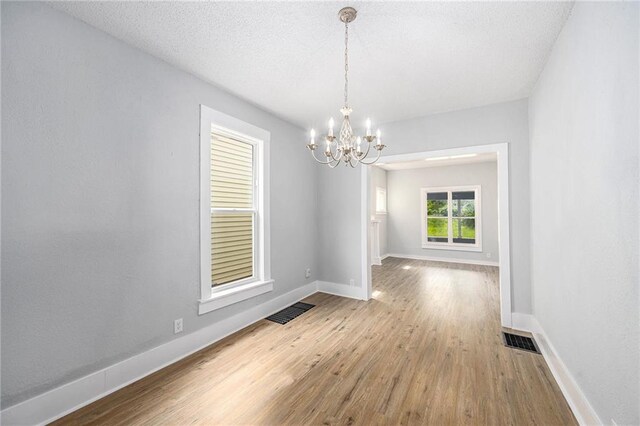 2206 E 30th St, Kansas City, MO 64109 - unfurnished room featuring a chandelier and wood finished floors