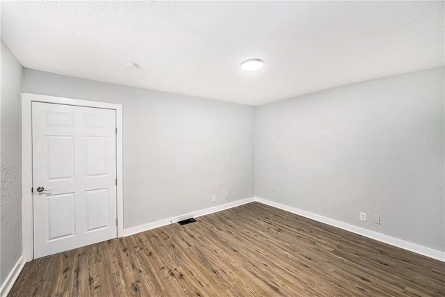 2206 E 30th St, Kansas City, MO 64109 - empty room with wood finished floors and baseboards