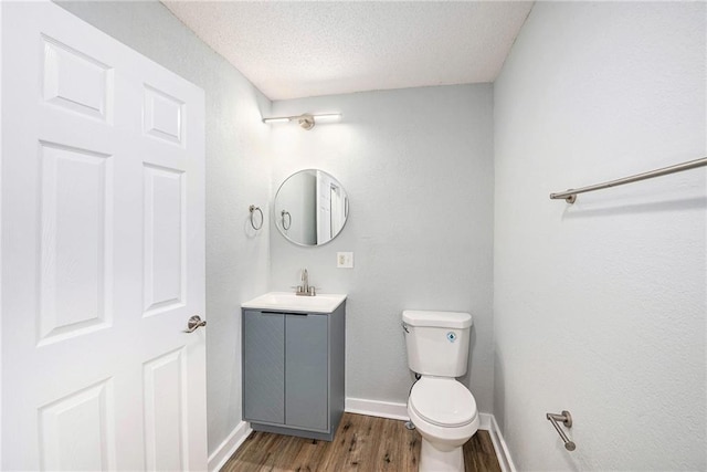 2206 E 30th St, Kansas City, MO 64109 - bathroom featuring wood finished floors, vanity, and a textured ceiling