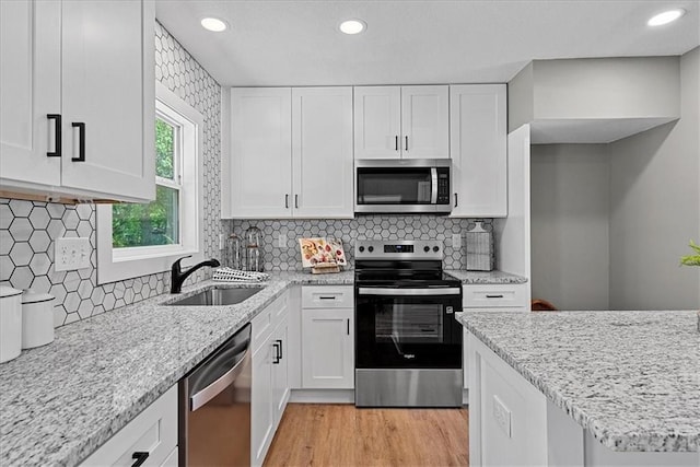 11424 W 68th Pl, Shawnee, KS 66203 - kitchen with stainless steel appliances, a sink, white cabinets, light stone counters, and recessed lighting