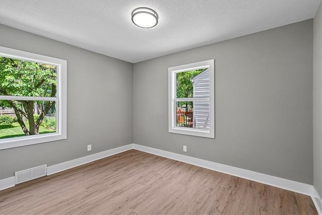 11424 W 68th Pl, Shawnee, KS 66203 - unfurnished room with plenty of natural light, wood finished floors, baseboards, and a textured ceiling