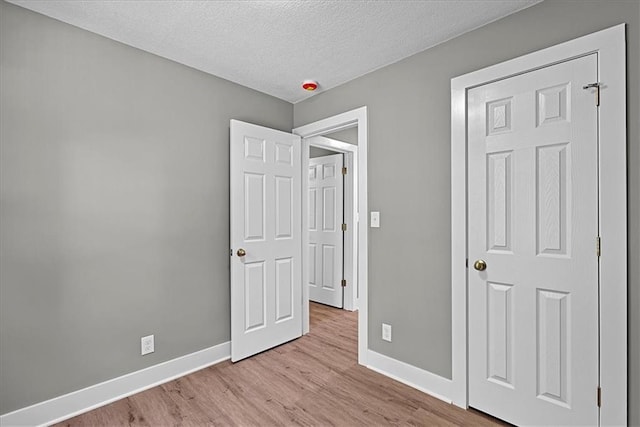 11424 W 68th Pl, Shawnee, KS 66203 - unfurnished bedroom with baseboards, wood finished floors, and a textured ceiling