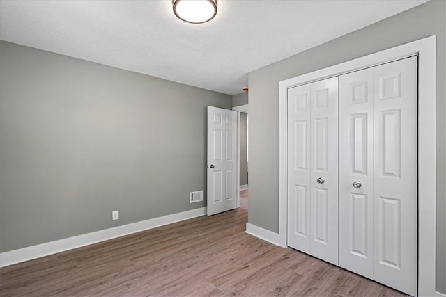 11424 W 68th Pl, Shawnee, KS 66203 - unfurnished bedroom with wood finished floors, baseboards, a closet, and a textured ceiling