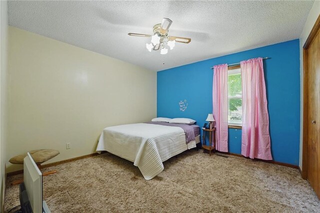 bedroom featuring carpet, baseboards, a textured ceiling, a ceiling fan, and a closet