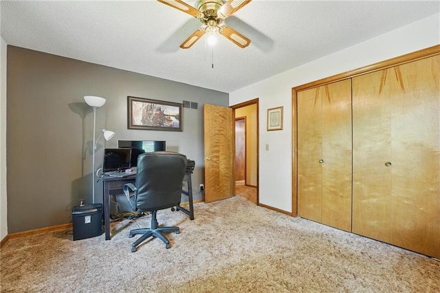 carpeted home office with baseboards and a ceiling fan