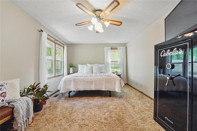 bedroom featuring carpet, a textured ceiling, ceiling fan, and baseboards