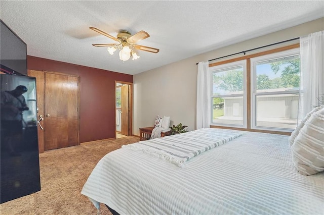 carpeted bedroom with a textured ceiling and a ceiling fan