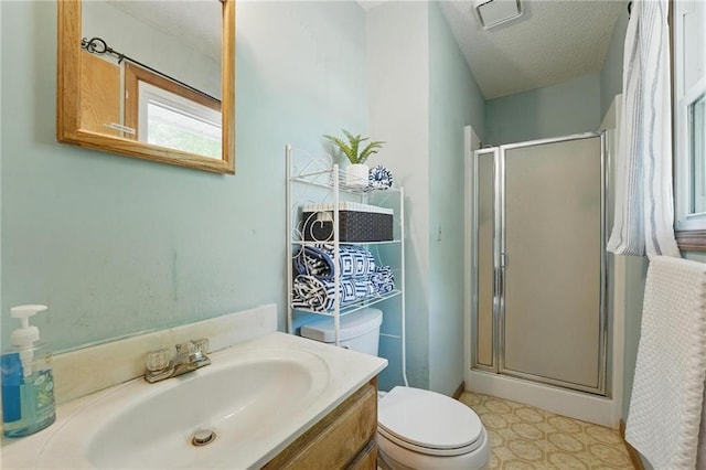 full bathroom with a shower stall, toilet, vanity, and a textured ceiling