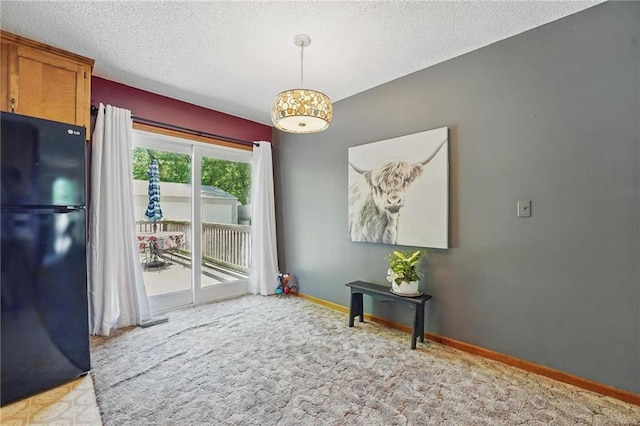 entryway featuring light colored carpet, a textured ceiling, and baseboards