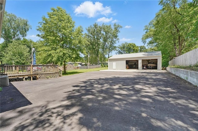 view of property's community featuring a garage, an outbuilding, fence, and a wooden deck