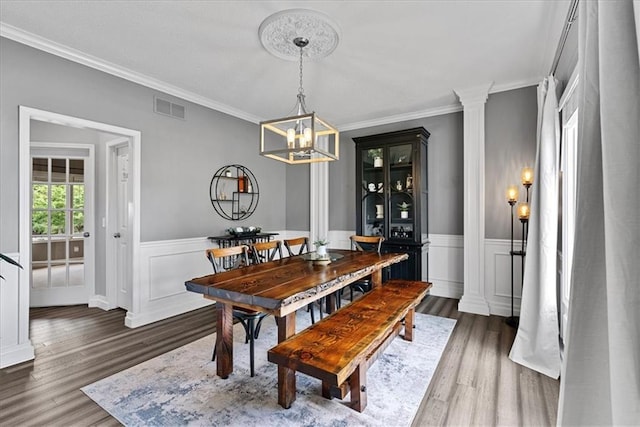 19600 W 98th St, Lenexa, KS 66220 - dining area featuring wood finished floors, ornamental molding, a wainscoted wall, and a chandelier