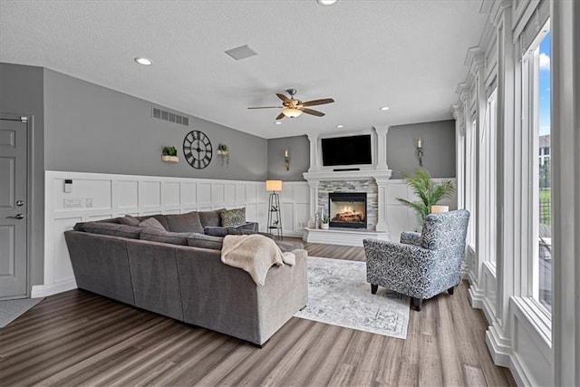 19600 W 98th St, Lenexa, KS 66220 - living room with ceiling fan, wood finished floors, a lit fireplace, a textured ceiling, and recessed lighting