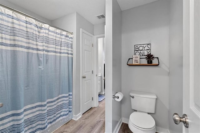 19600 W 98th St, Lenexa, KS 66220 - bathroom featuring wood finished floors, toilet, baseboards, and a shower with shower curtain