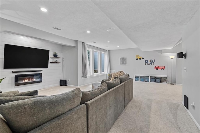 19600 W 98th St, Lenexa, KS 66220 - carpeted living room with a textured ceiling, baseboards, a glass covered fireplace, and recessed lighting