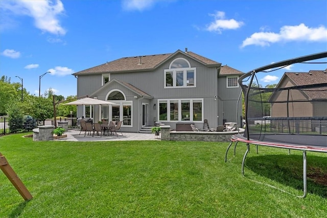 19600 W 98th St, Lenexa, KS 66220 - back of house featuring a trampoline, a patio, and a lawn