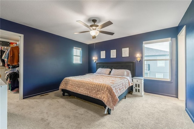 bedroom featuring a spacious closet, carpet floors, a closet, and ceiling fan