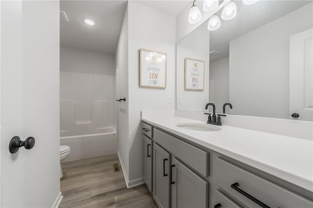 full bath featuring wood finished floors, vanity, baseboards, toilet, and recessed lighting