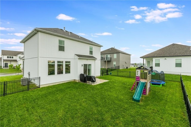 rear view of house with a trampoline and a playground