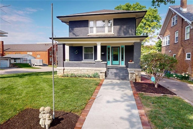 american foursquare style home featuring brick siding, a front lawn, and covered porch