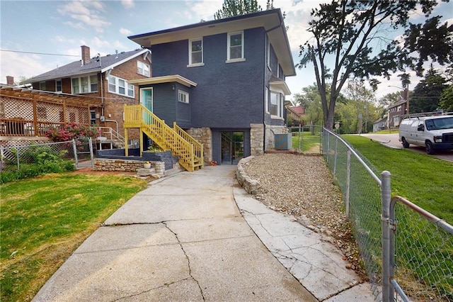 back of house featuring stone siding, concrete driveway, stairway, and cooling unit