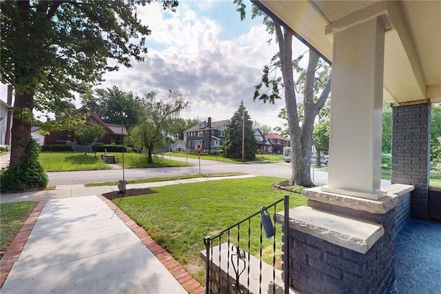 view of green lawn featuring a residential view