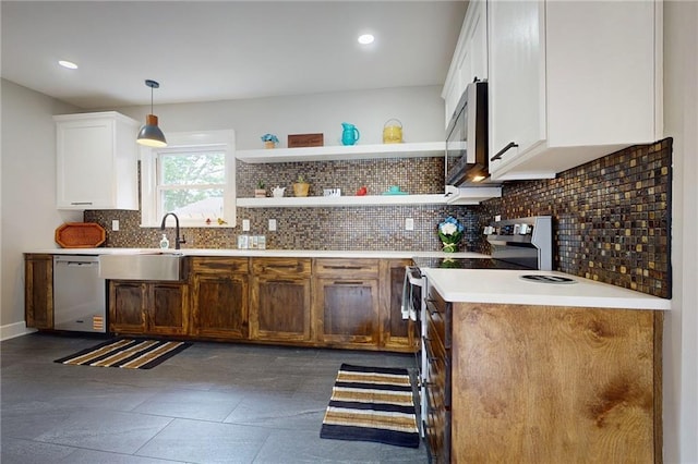 kitchen with appliances with stainless steel finishes, decorative backsplash, white cabinetry, pendant lighting, and light countertops