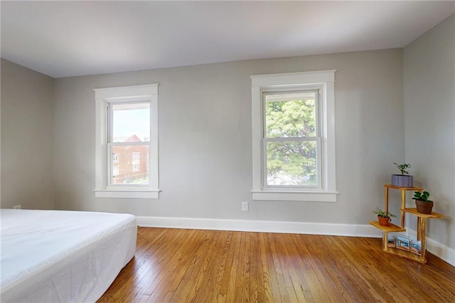 bedroom with wood-type flooring and baseboards