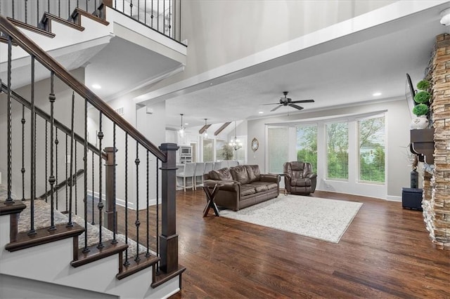 17817 Grandview St, Overland Park, KS 66013 - living room featuring ceiling fan, wood finished floors, stairs, a towering ceiling, and baseboards