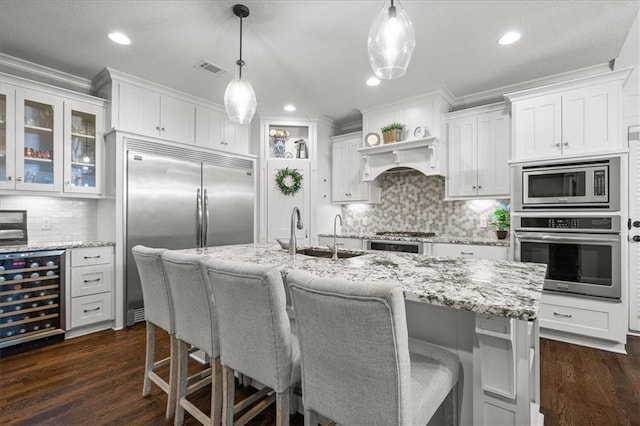 17817 Grandview St, Overland Park, KS 66013 - kitchen with built in appliances, wine cooler, a sink, ornamental molding, and white cabinetry