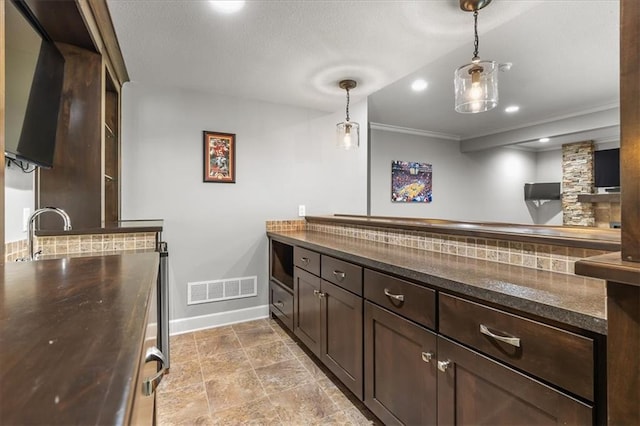 17817 Grandview St, Overland Park, KS 66013 - kitchen with dark brown cabinets, baseboards, dark countertops, pendant lighting, and crown molding