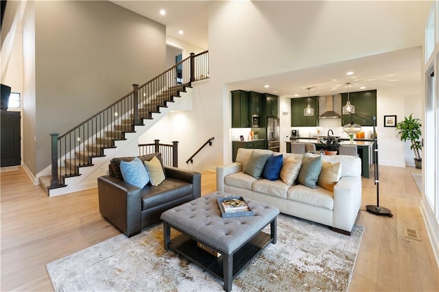 17328 Richards St, Overland Park, KS 66221 - living room with stairway, light wood finished floors, a high ceiling, recessed lighting, and baseboards