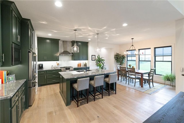 17328 Richards St, Overland Park, KS 66221 - kitchen featuring green cabinetry, wall chimney exhaust hood, appliances with stainless steel finishes, a sink, and recessed lighting