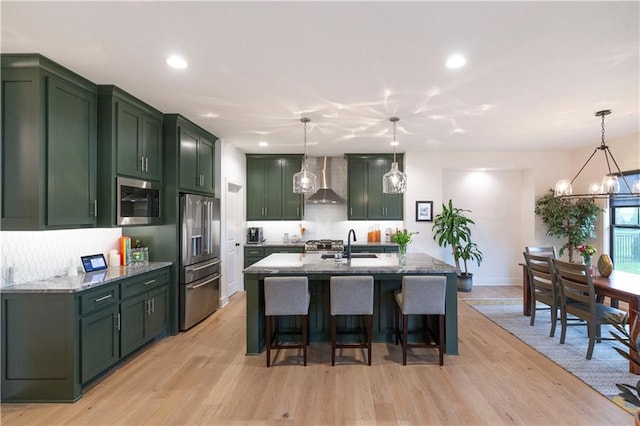 17328 Richards St, Overland Park, KS 66221 - kitchen featuring green cabinets, stainless steel appliances, wall chimney range hood, light wood-style floors, and recessed lighting