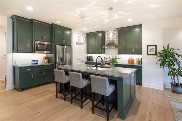 17328 Richards St, Overland Park, KS 66221 - kitchen featuring stainless steel appliances, a sink, green cabinetry, dark stone countertops, and decorative backsplash