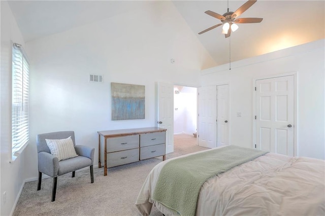 bedroom with high vaulted ceiling, light carpet, multiple windows, baseboards, and ceiling fan