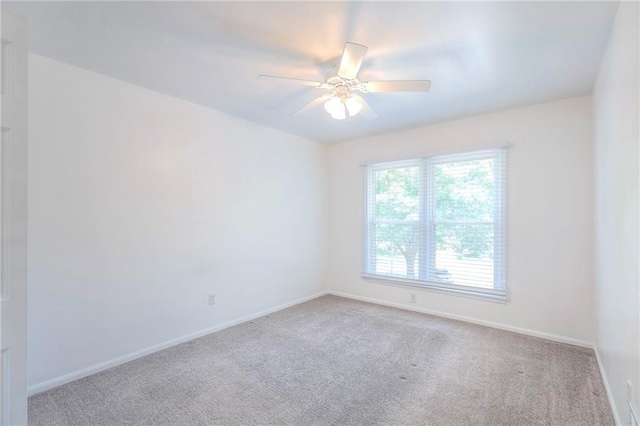 empty room featuring carpet, baseboards, and a ceiling fan
