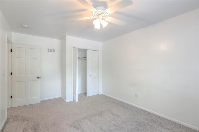 unfurnished bedroom with light carpet, baseboards, a closet, and ceiling fan