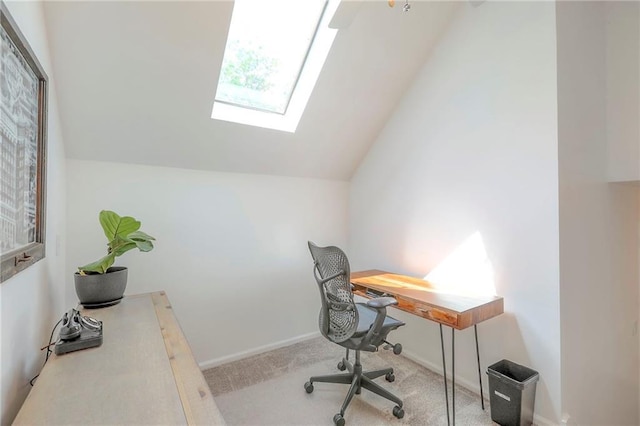carpeted home office featuring a skylight, vaulted ceiling, and healthy amount of natural light