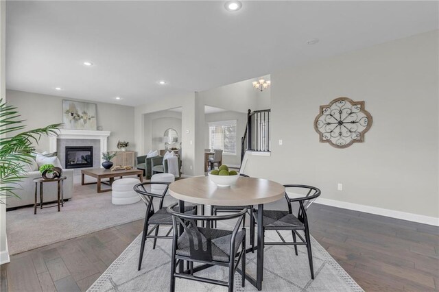 16967 S Laurelwood St, Olathe, KS 66062 - dining area featuring a tile fireplace, wood finished floors, baseboards, recessed lighting, and a chandelier