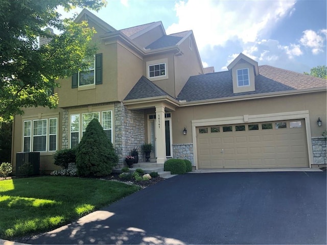 16141 Linden St, Stilwell, KS 66085 - view of front of home with stone siding, stucco siding, central AC unit, driveway, and a front lawn