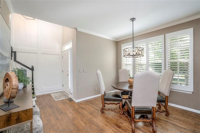 16141 Linden St, Stilwell, KS 66085 - dining space with a chandelier, wood finished floors, crown molding, and baseboards