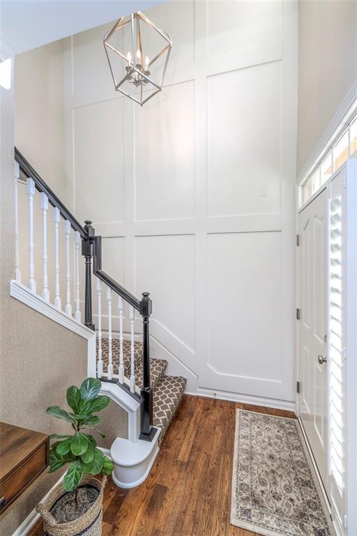 16141 Linden St, Stilwell, KS 66085 - entrance foyer featuring wood finished floors, stairs, a decorative wall, and a chandelier