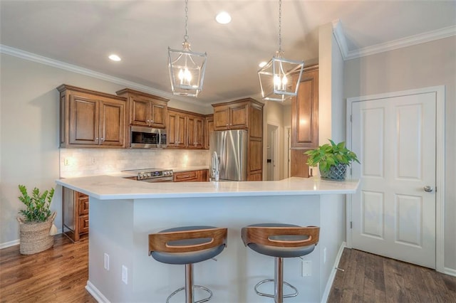 16141 Linden St, Stilwell, KS 66085 - kitchen featuring appliances with stainless steel finishes, brown cabinetry, crown molding, tasteful backsplash, and a breakfast bar