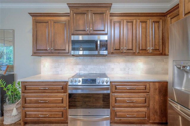 16141 Linden St, Stilwell, KS 66085 - kitchen featuring stainless steel appliances, light countertops, crown molding, tasteful backsplash, and brown cabinets